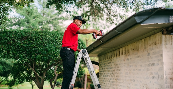 Technician inspecting gutters