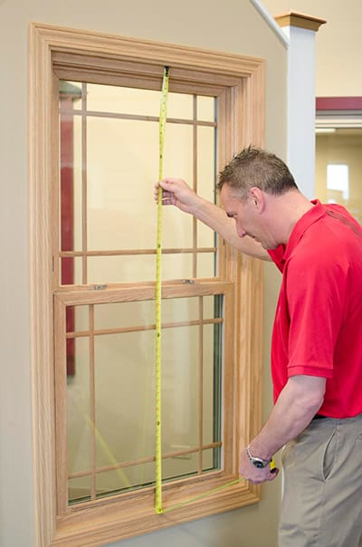 Professional window installer measuring frame